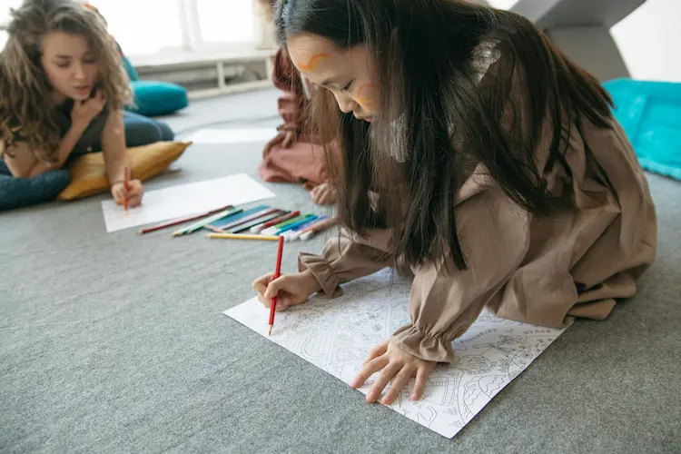 Children color with their therapist during a counseling session